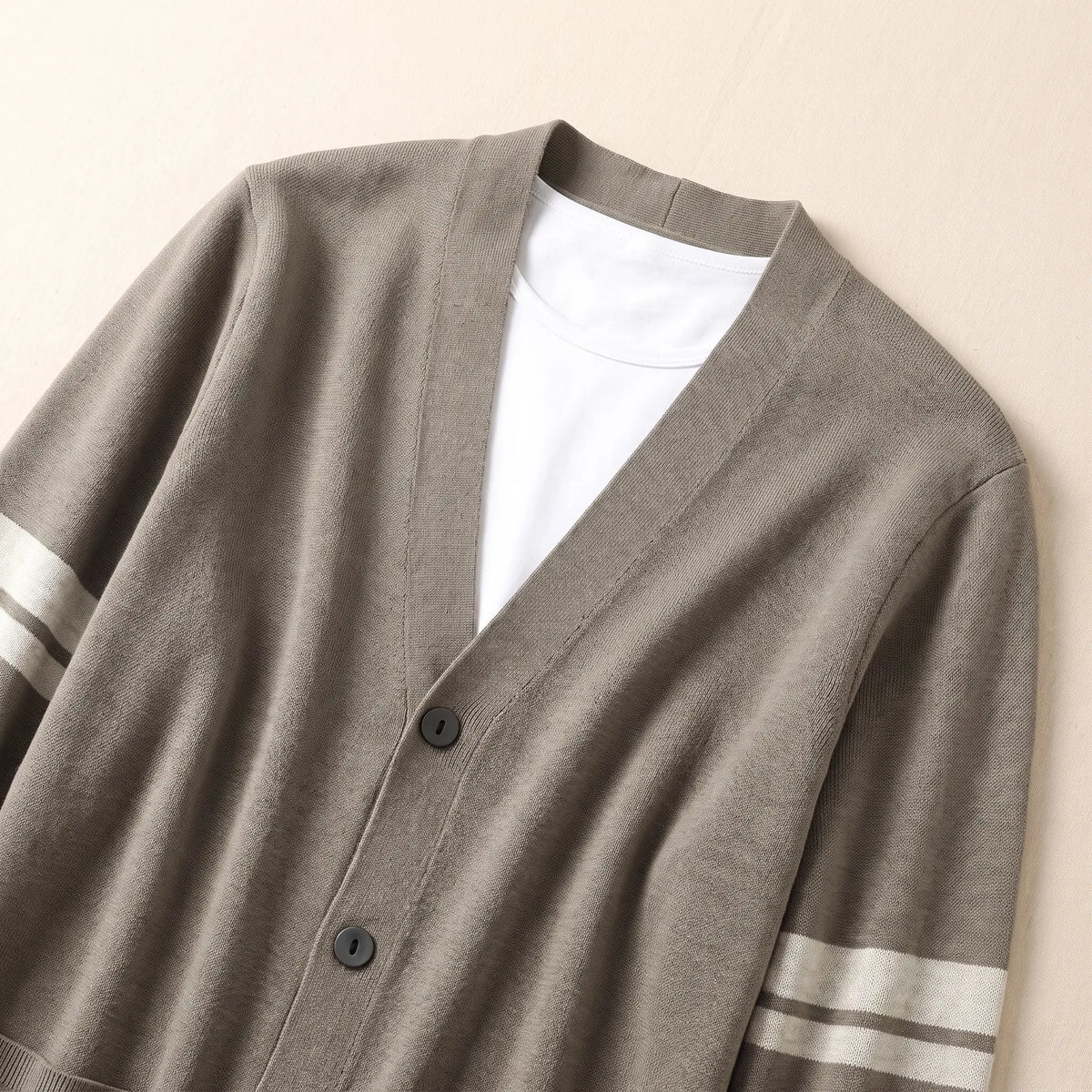 Close-up of men's khaki V-neck knit cardigan neckline and buttons