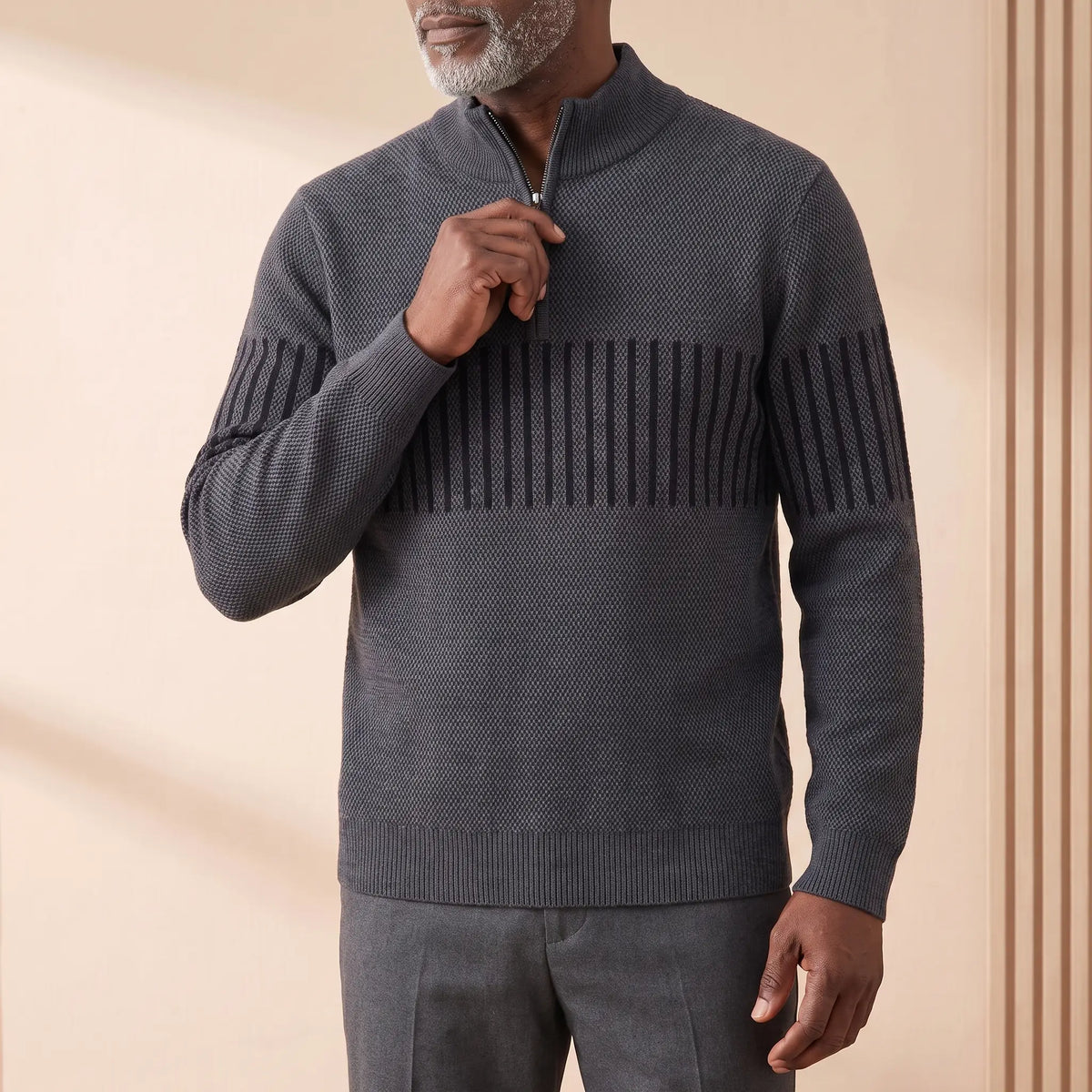 Man zipping up the STRIPE BAND SWEATER in dark gray