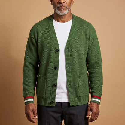 Man wearing the Stripe Cuff Cardigan in green, a textured knit V-neck cardigan with red and white striped cuffs, worn open over a white tee