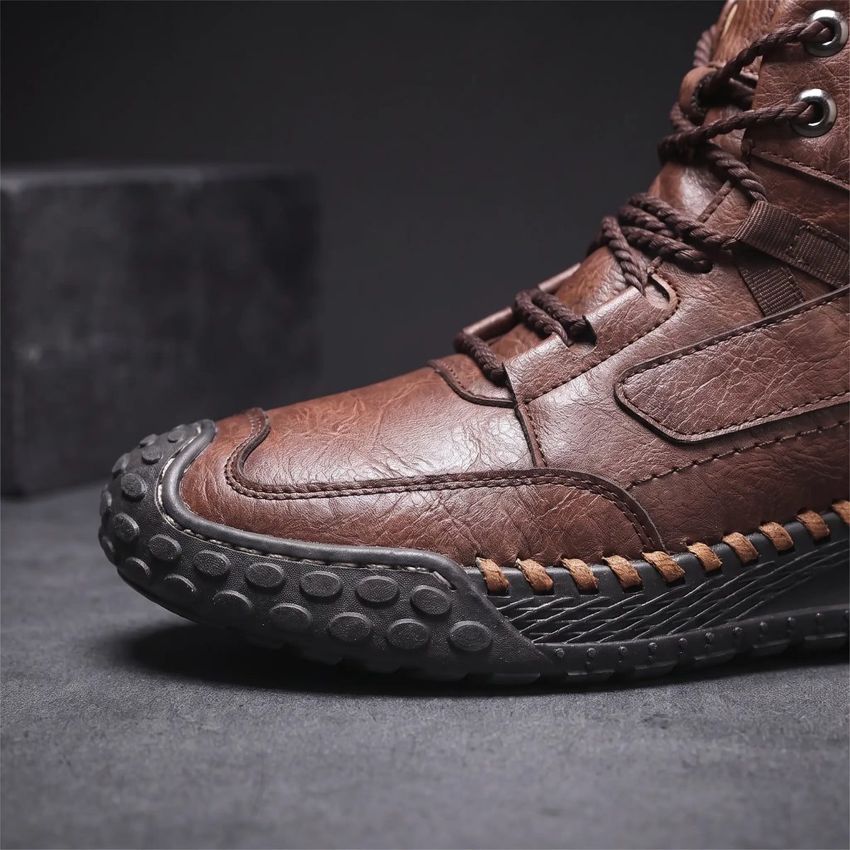 Close detail of STUDDED SOLE BOOTS showing the hand-stitched sole edge and studded rubber outsole