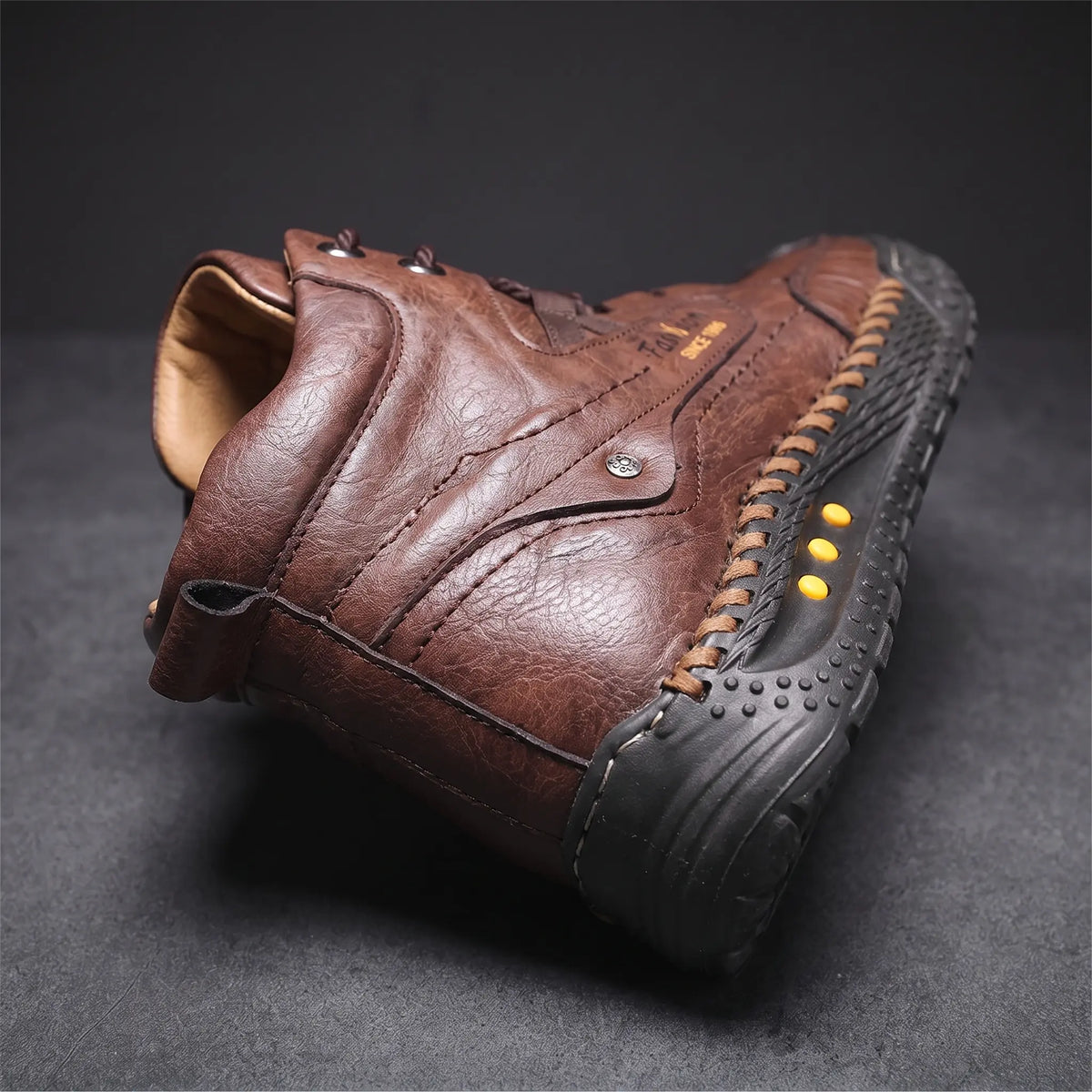 Close detail of STUDDED SOLE BOOTS showing the padded ankle collar and heel pull loop