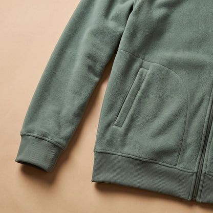 Close detail of TALL COLLAR FLEECE showing the ribbed cuff, slash pocket and hem
