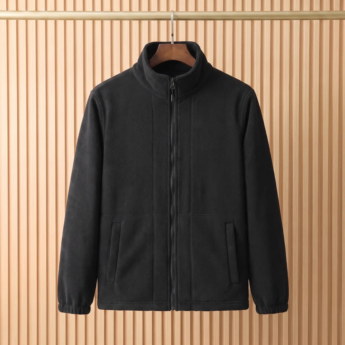 THICK POLAR FLEECE in Black - polar fleece jacket with tall stand collar and full front zip, on a wooden hanger