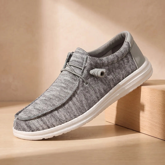 Toggle lace moccasins in grey heather knit on a pale oak block