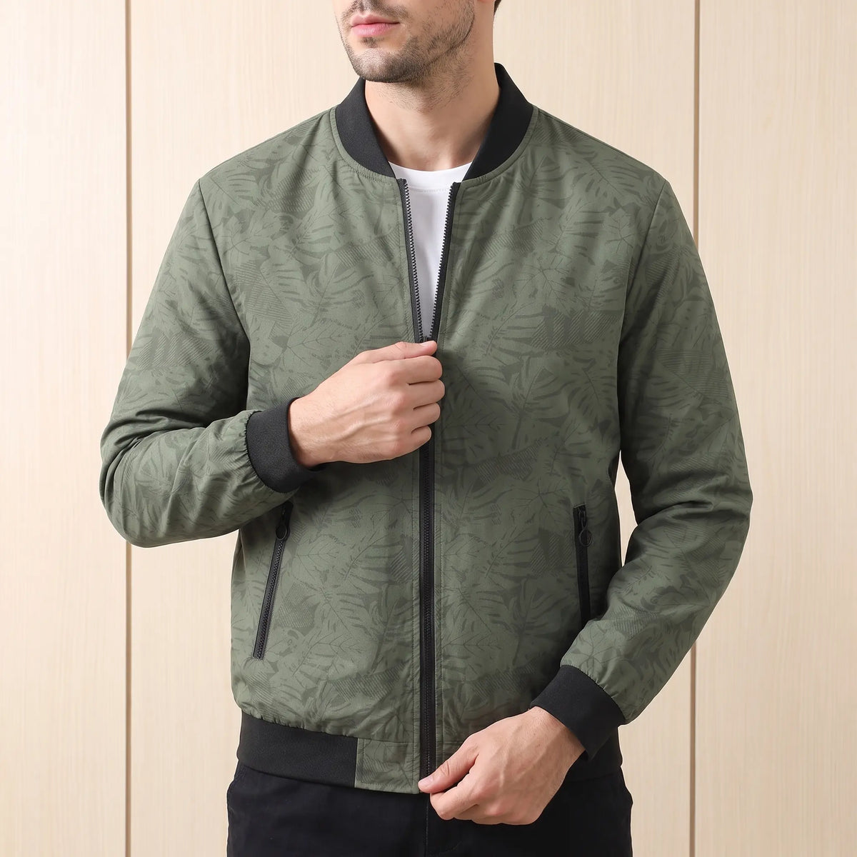 Man zipping up green print bomber