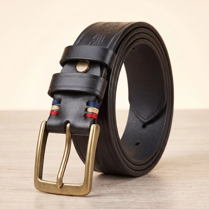 Tooled cowhide belt in black with antique brass pin buckle and embossed scroll pattern