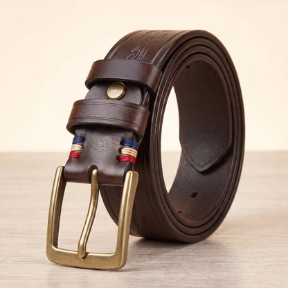 Tooled cowhide belt in brown with antique brass pin buckle and embossed scroll pattern