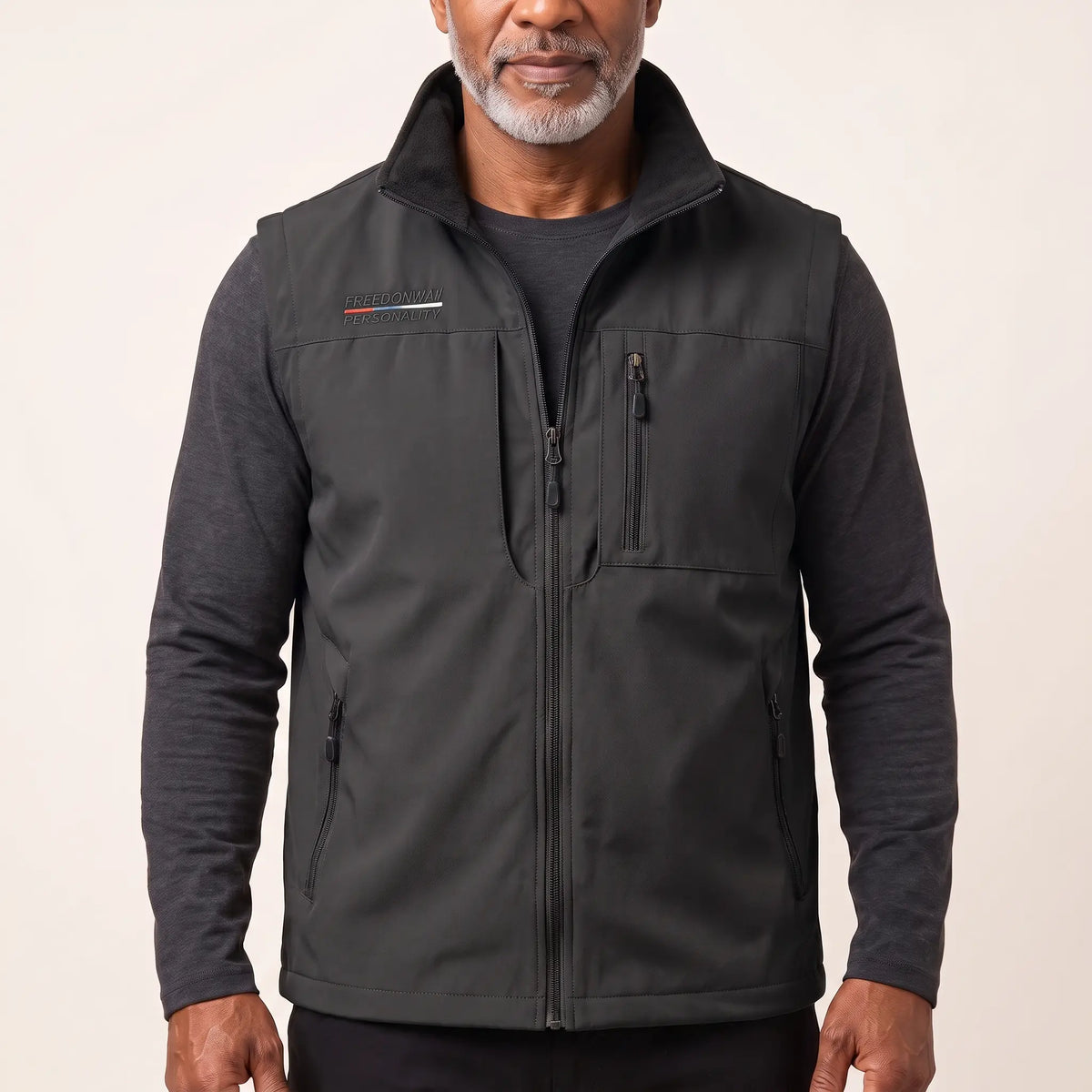 Man wearing the black zip-front outdoor vest over a charcoal long-sleeve top