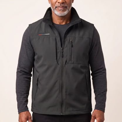 Man wearing the black zip-front outdoor vest over a charcoal long-sleeve top