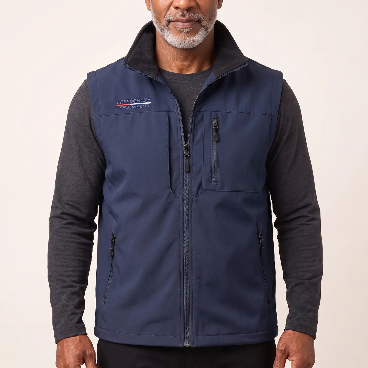 Man wearing the navy blue zip-front outdoor vest over a charcoal long-sleeve top
