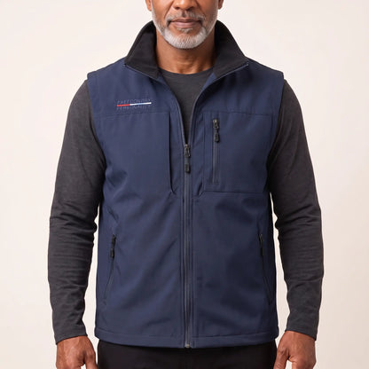 Man wearing the navy blue zip-front outdoor vest over a charcoal long-sleeve top