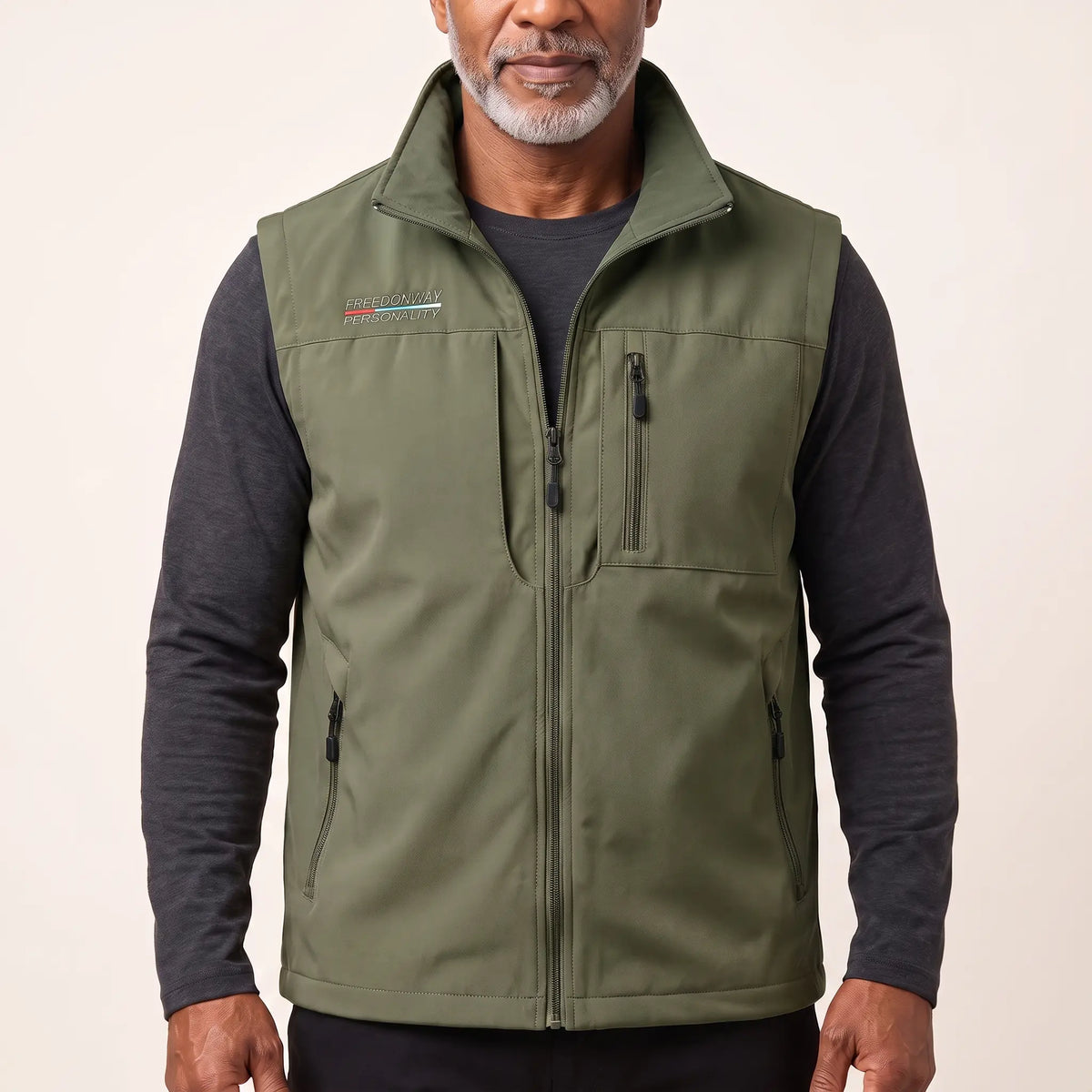 Man wearing the army green zip-front outdoor vest over a charcoal long-sleeve top