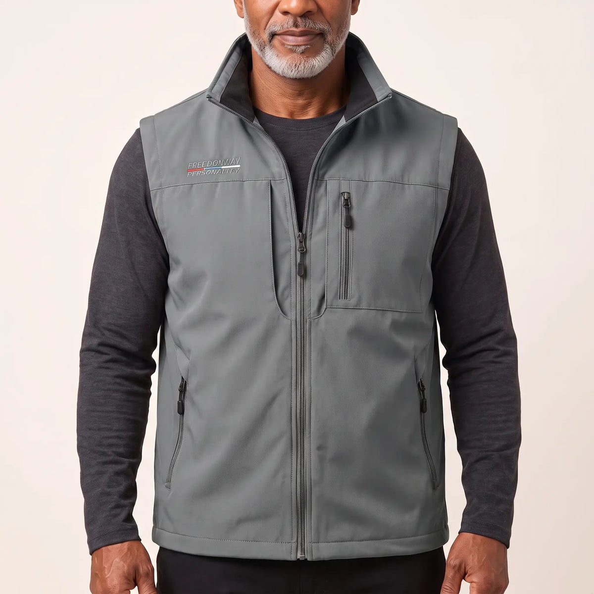 Man wearing the grey zip-front outdoor vest over a charcoal long-sleeve top