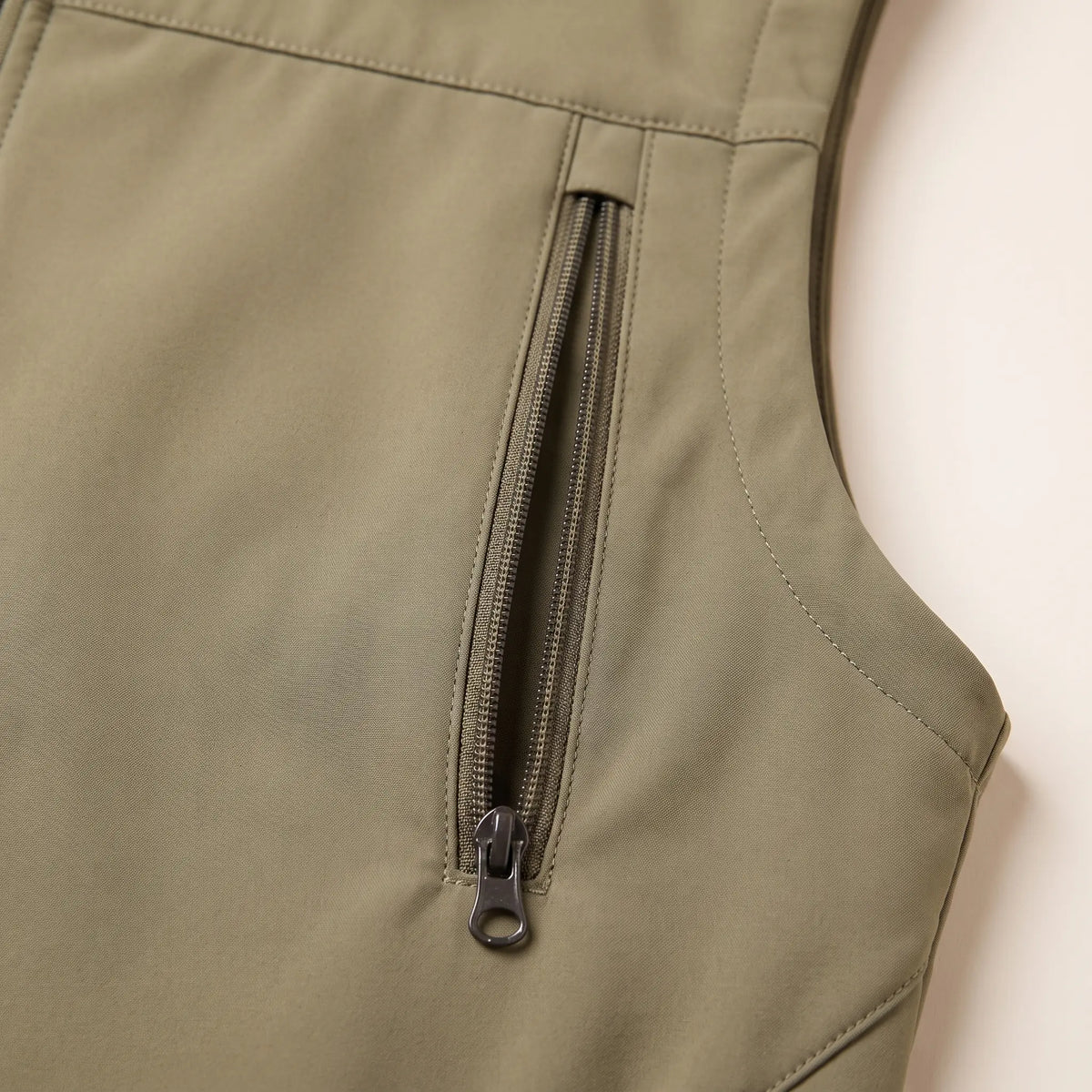 Close-up of a vertical zip chest pocket on the khaki vest
