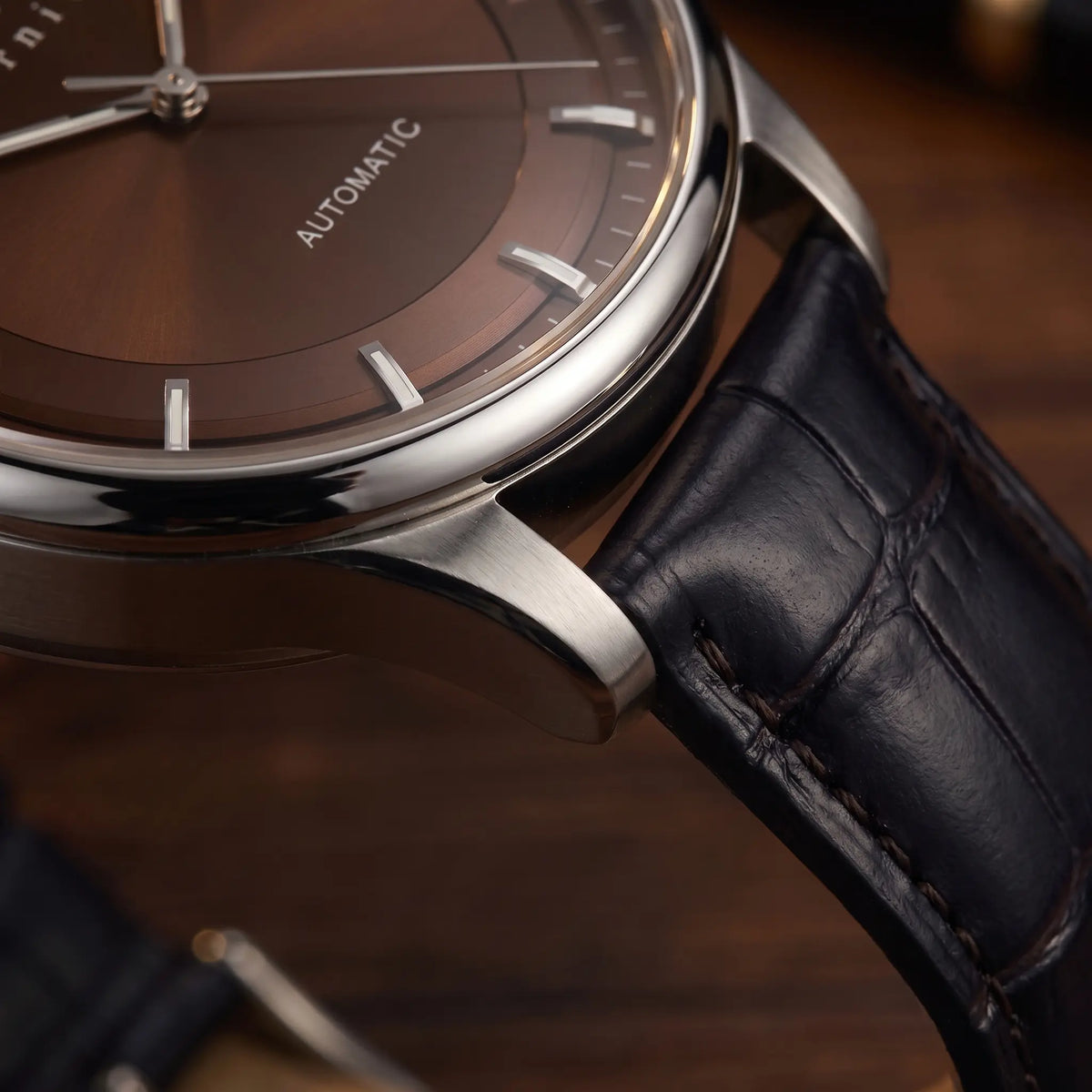 Close up of the polished case and lug on the brown dial automatic watch