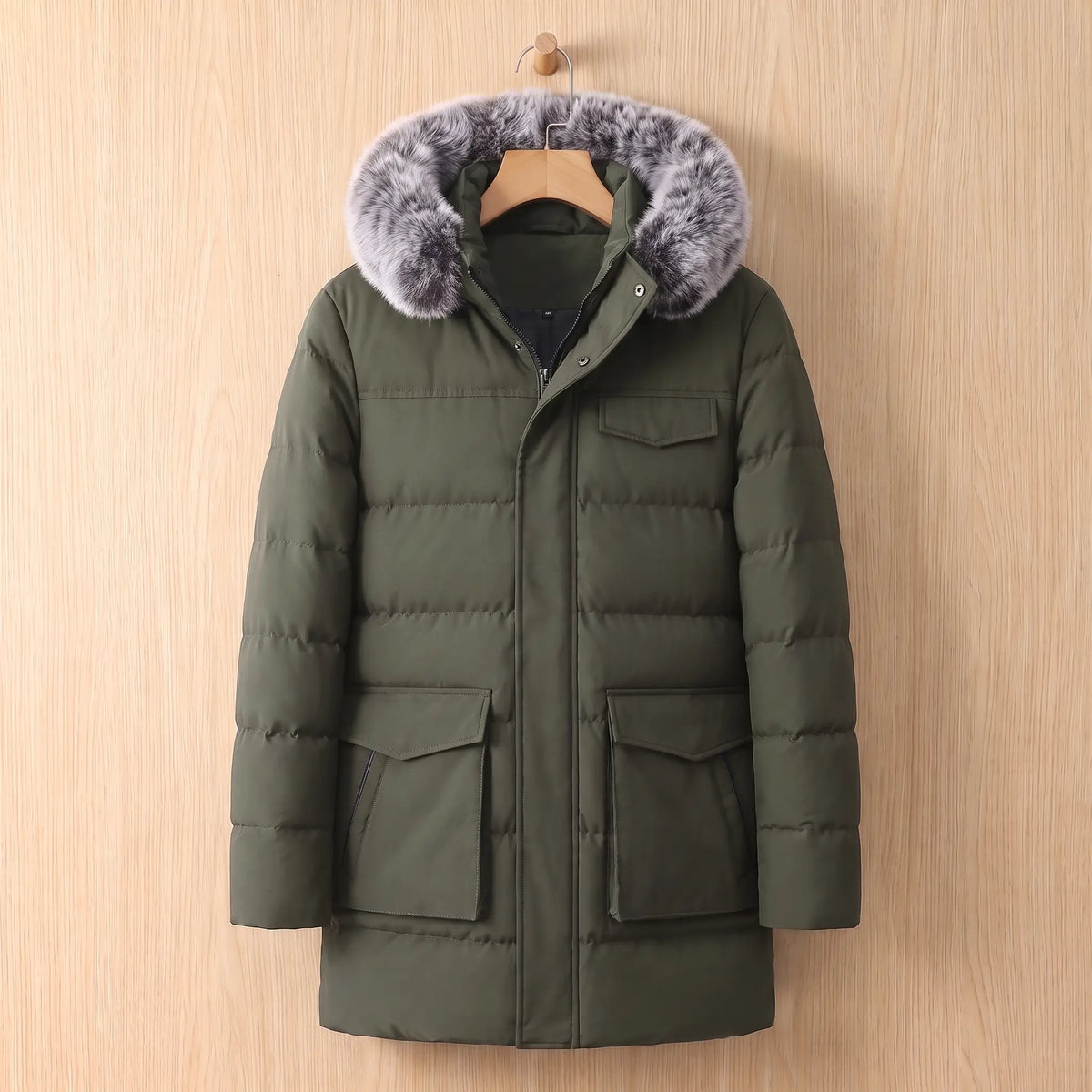 Green warm longline parka for men with fur trimmed hood on a wooden hanger