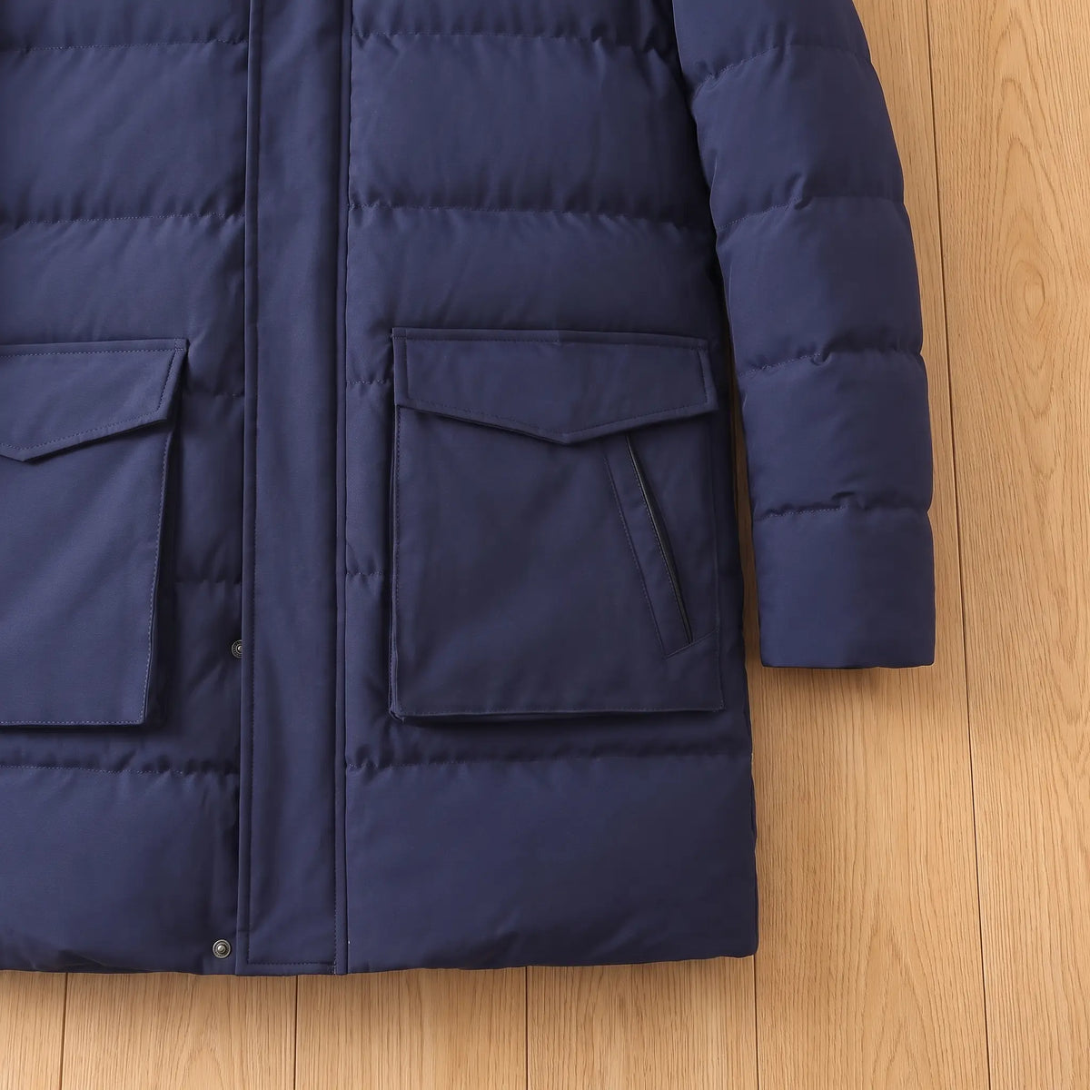 Large flap pockets and quilted hem on a navy blue warm longline parka for men