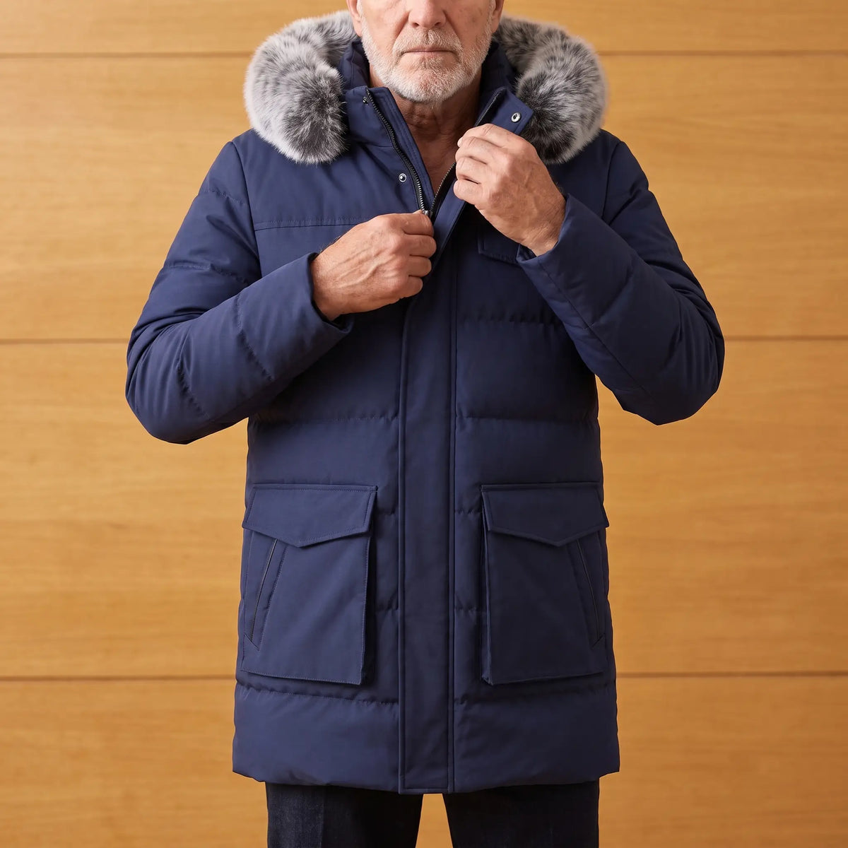 Man zipping up a navy blue warm longline parka with fur trimmed hood