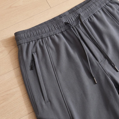 Close up of the WARM TRAIL JOGGERS elastic drawcord waist and zip pocket