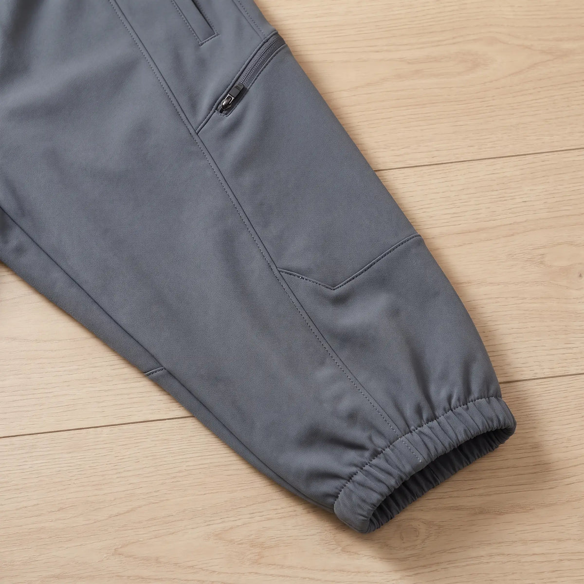 Close up of the WARM TRAIL JOGGERS zip thigh pocket and cuffed hem