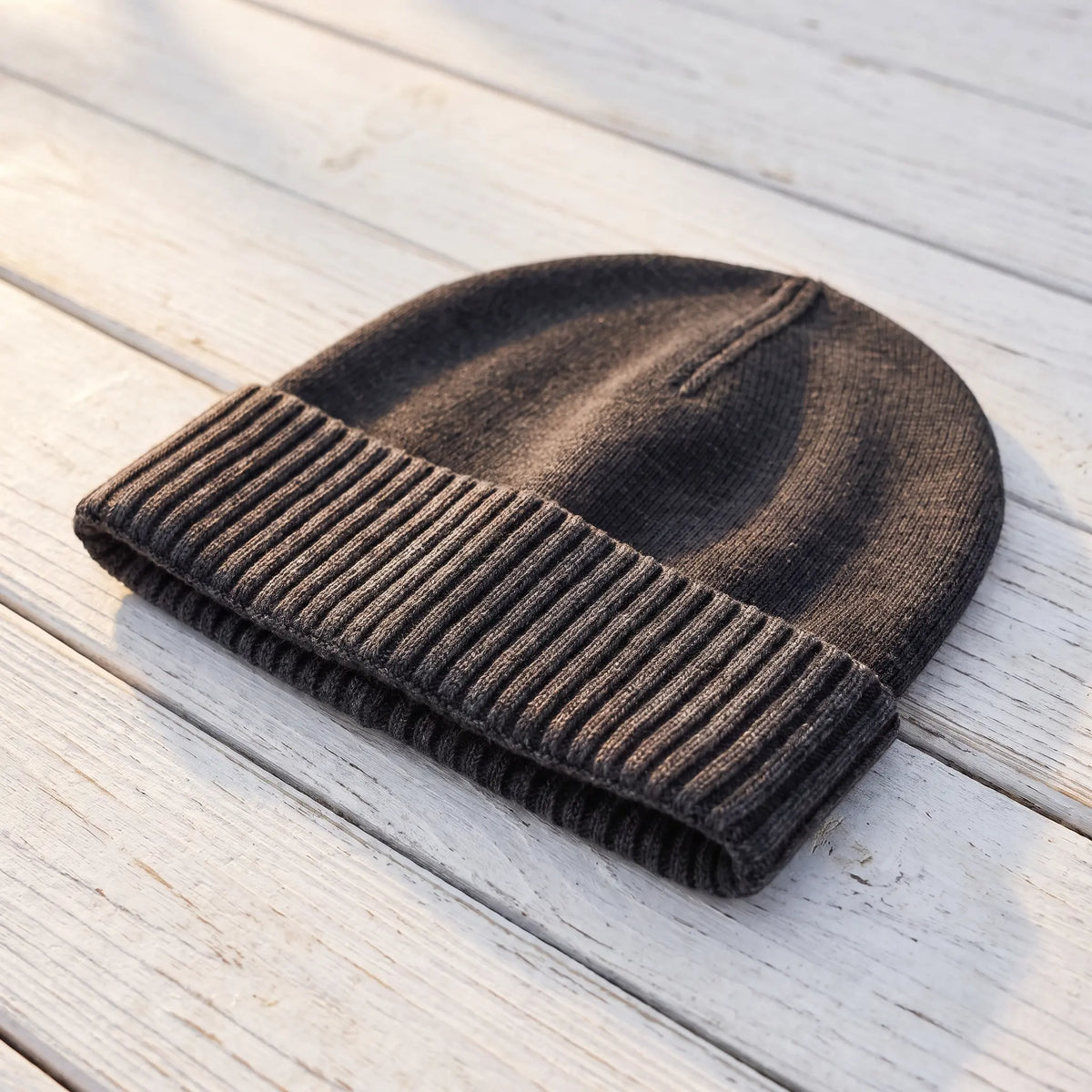Side view of the black washed knit beanie showing its short close fit