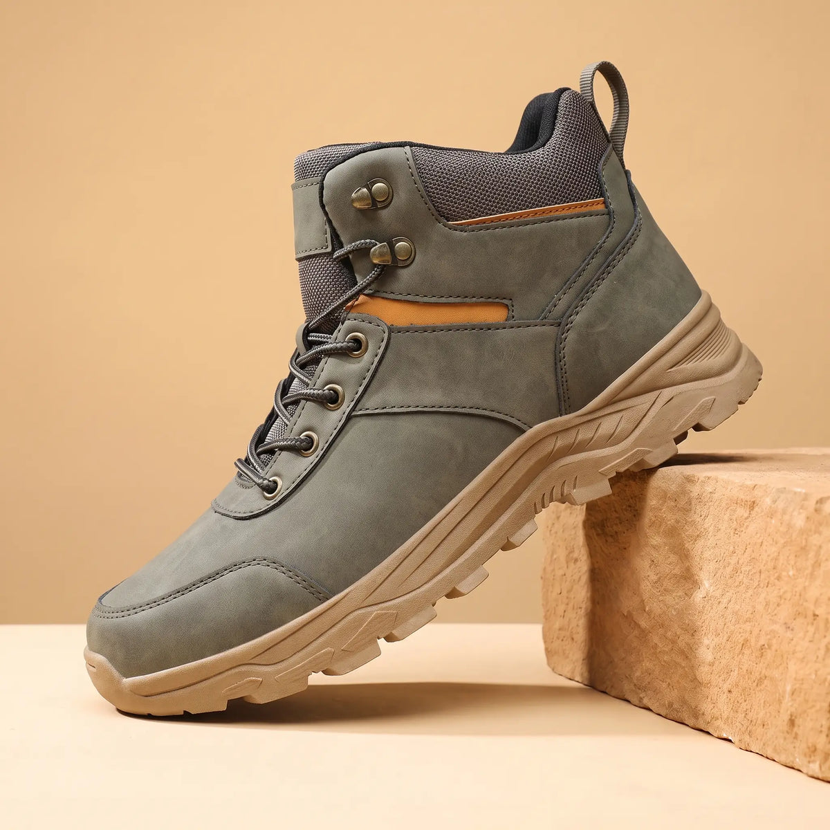 Green waterproof hiking boots for men, high-top lace-up boot on a sandstone block