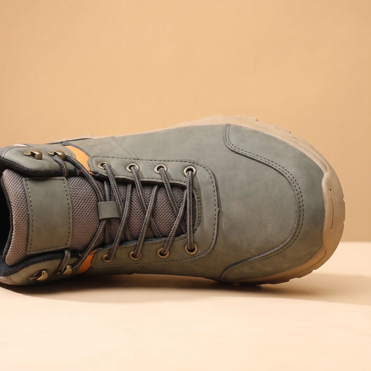 Close-up of the lacing and padded collar on green waterproof hiking boots for men