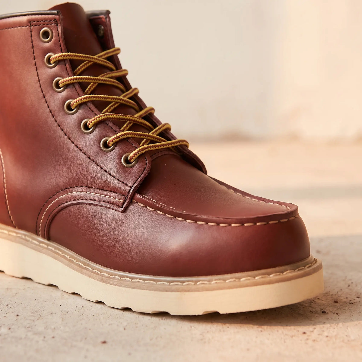 Close-up of the stitched moc toe and lacing on red waterproof leather boots for men