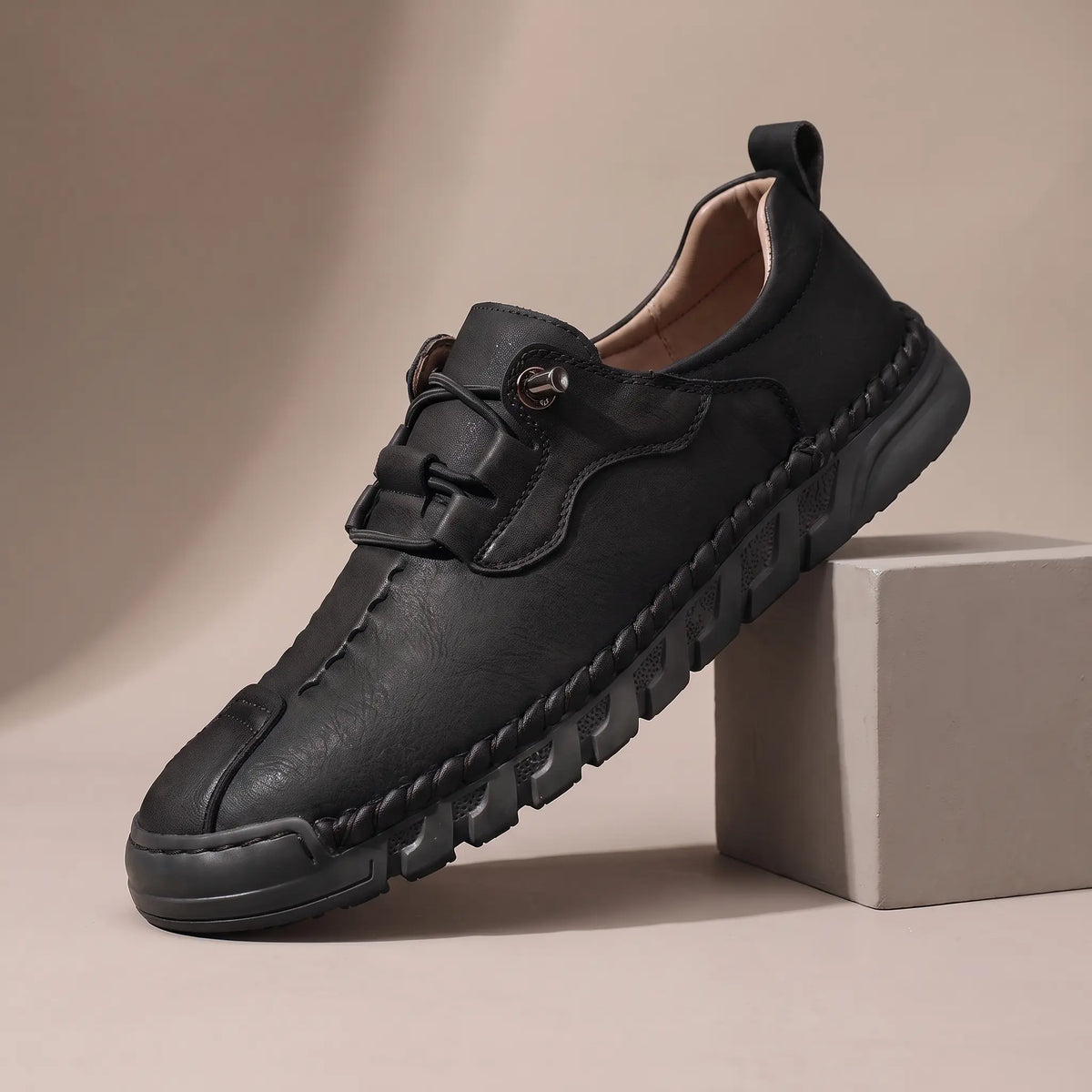 Men's black leather whipstitched moc-toe casual shoe with black ridged sole