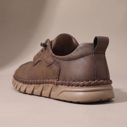 Close-up of the padded collar, heel pull tab and ridged sole on the brown casual shoe