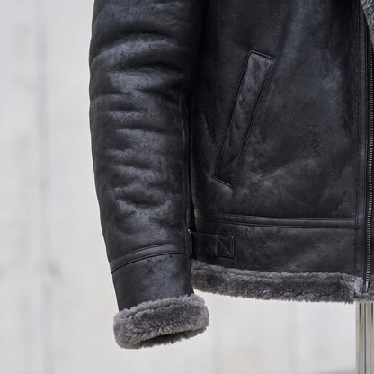 Close detail of WIDE COLLAR JACKET showing the shearling-trimmed cuff, welt pocket and hem