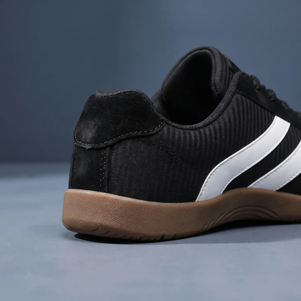 Rear close up of black wide toe sneakers showing the heel counter and gum sole edge