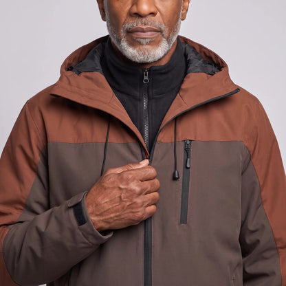 Man zipping the brown windproof hiking jacket over its black fleece