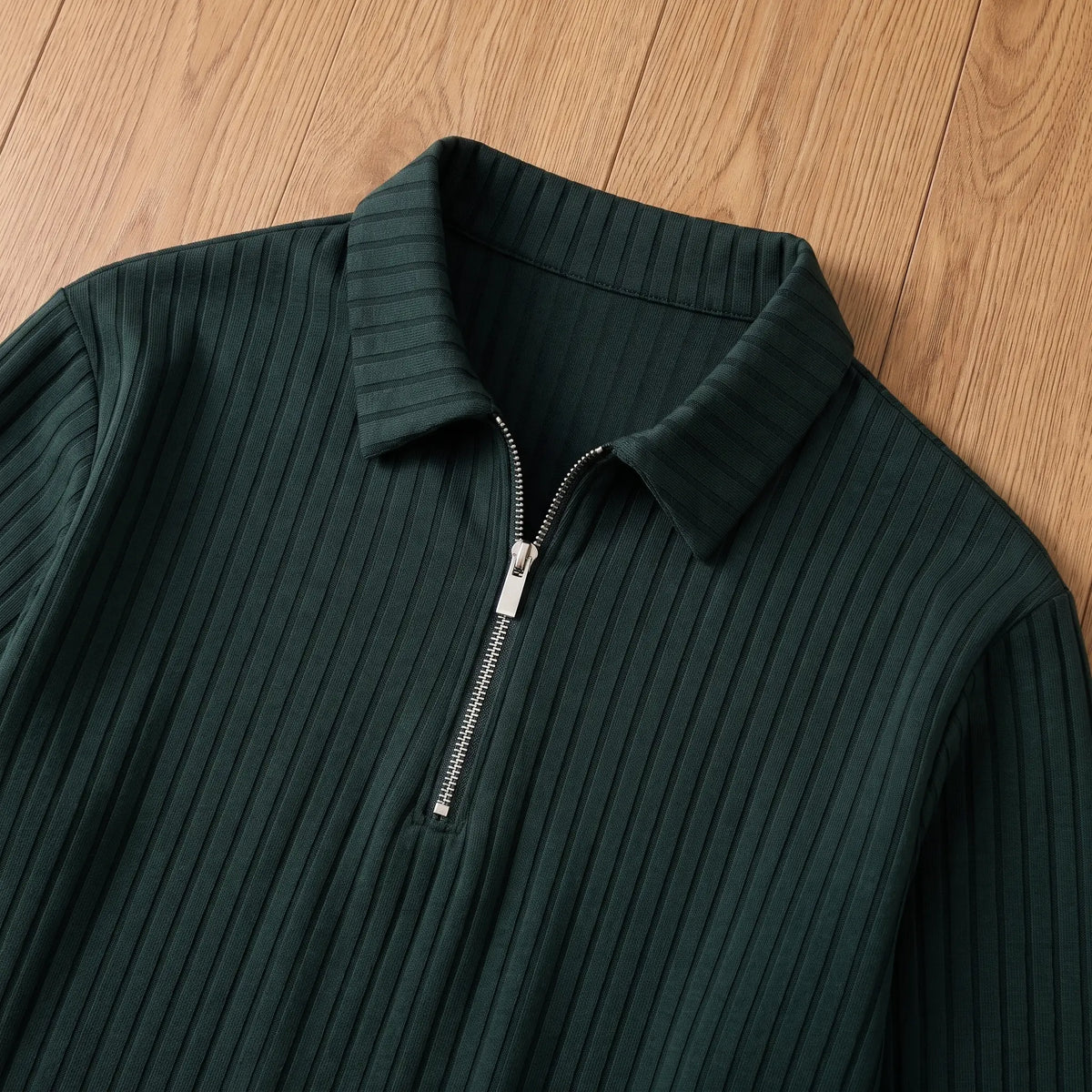 Close-up of green rib-knit polo pointed collar and silver quarter zip