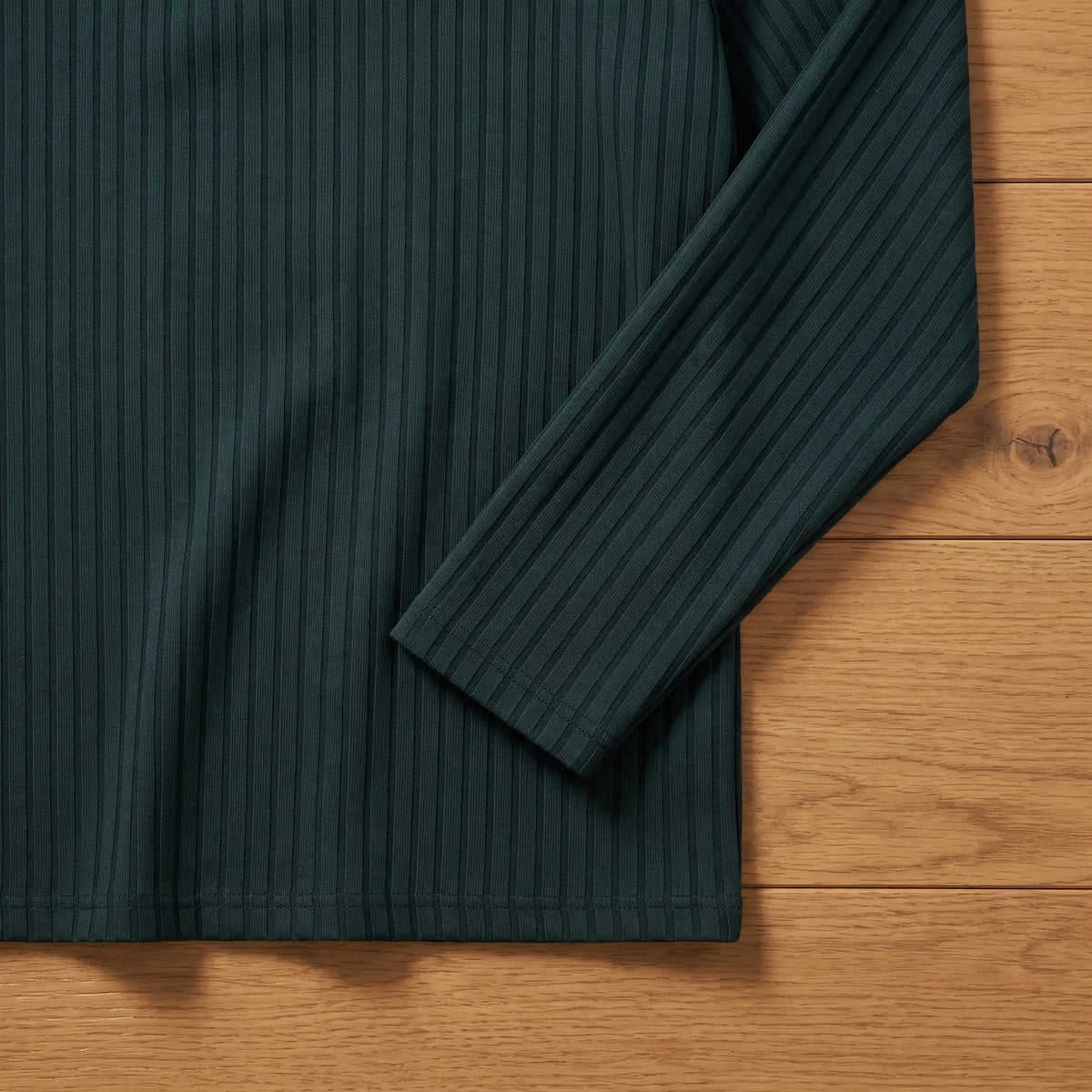 Close-up of green rib-knit polo sleeve end and hem