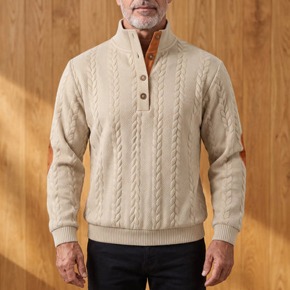 Men's oatmeal khaki cable knit henley sweater with stand collar, three-button placket and tan elbow patches, worn