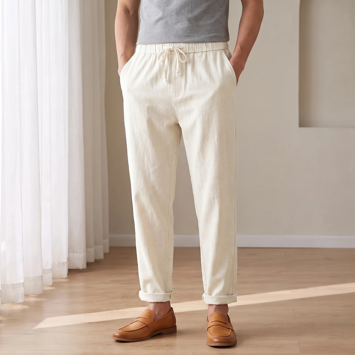 Drawstring cotton linen trousers in white, worn in a bright airy room