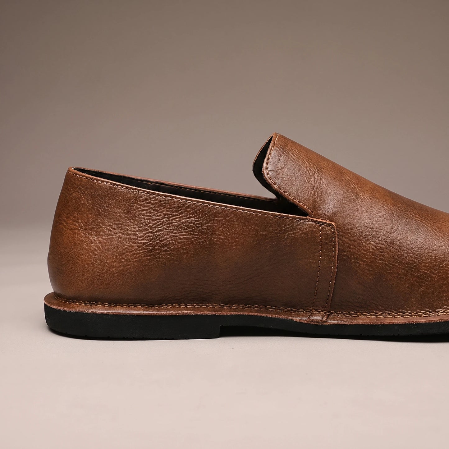 CLASSIC SLIP-ON LOAFERS side-profile close-up showing the leather grain and thin rubber sole edge