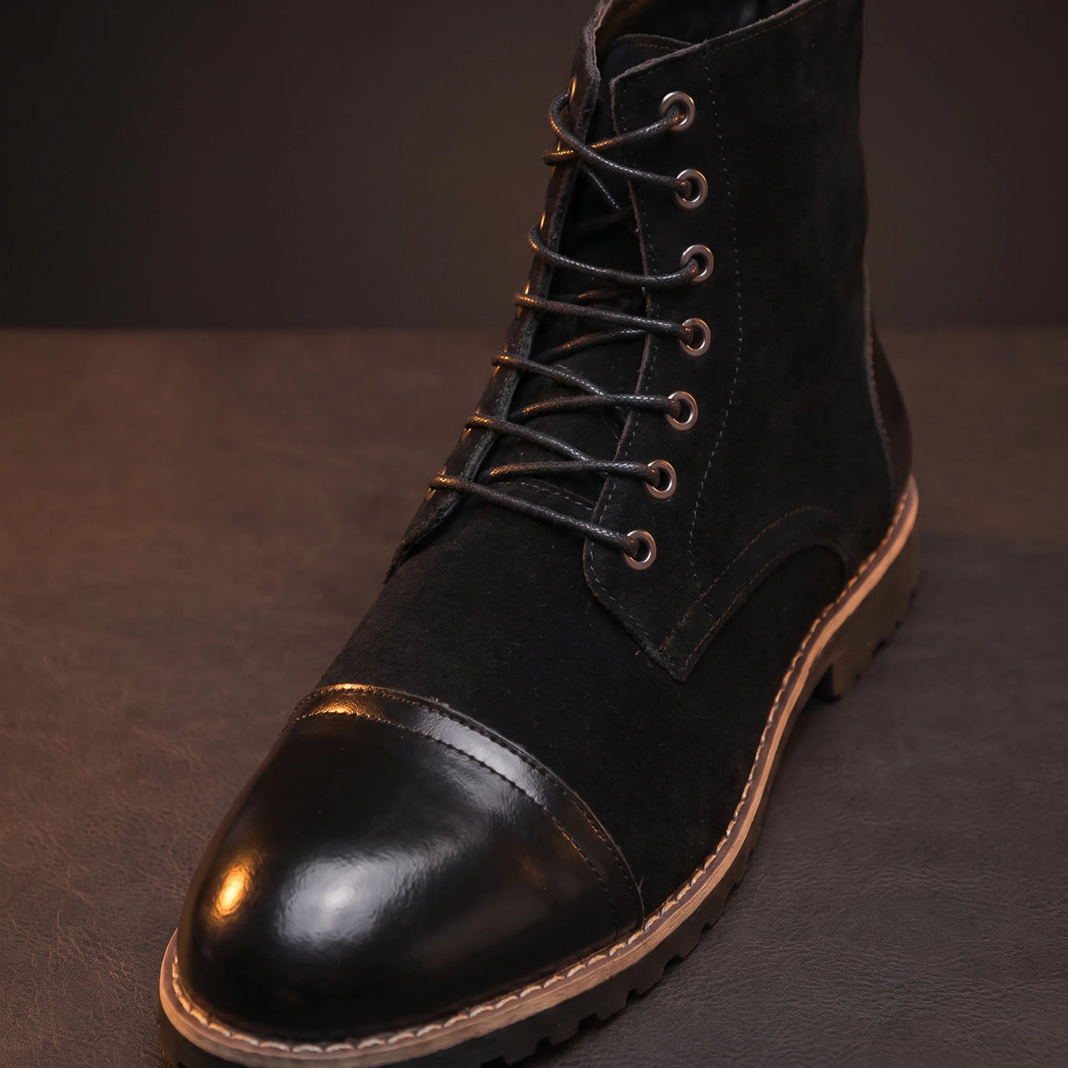 Close-up of black leather boot toe and lace-up detail