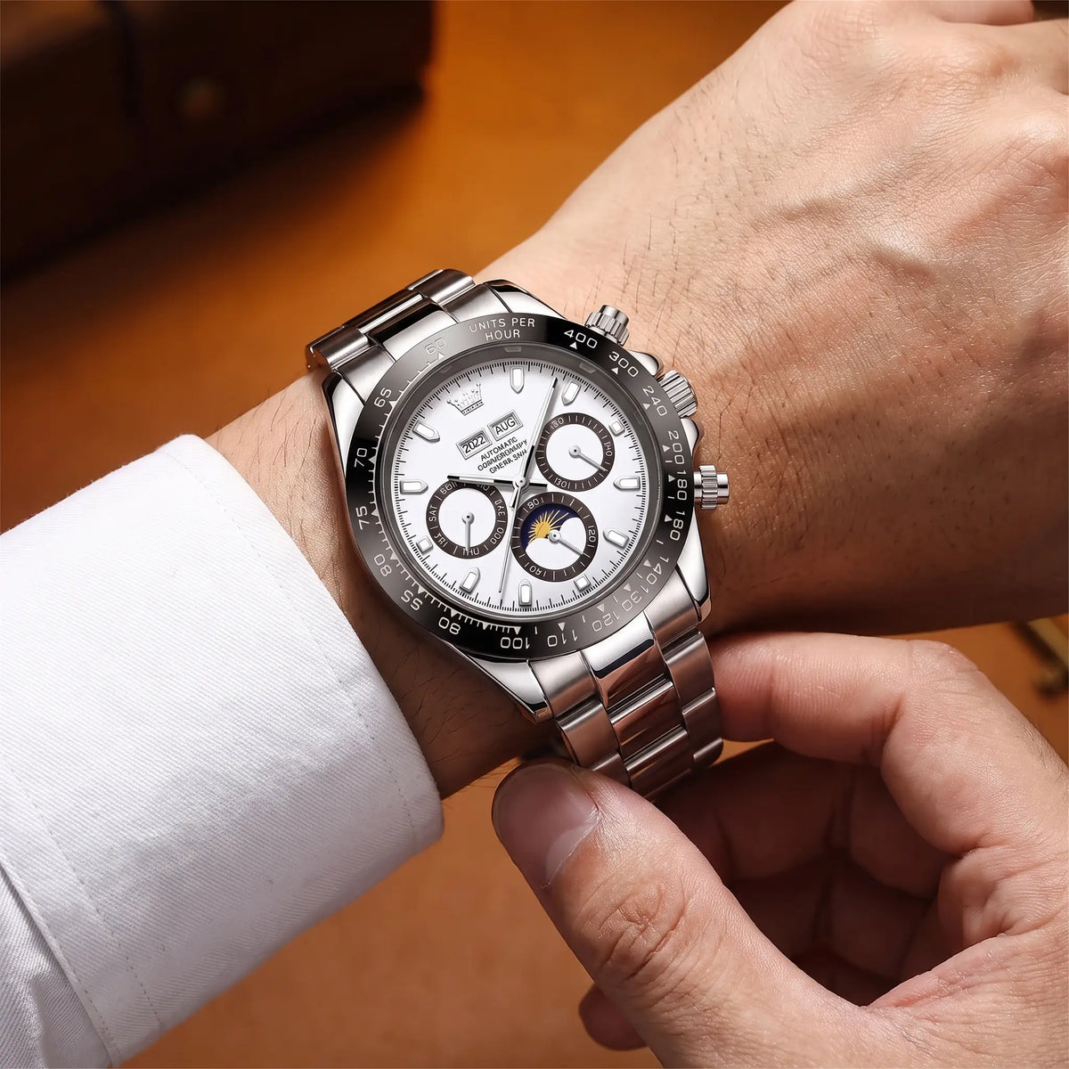 Man fastening the white dial Black Bezel Watch onto his wrist over a white shirt cuff