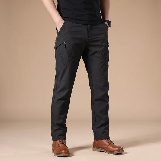 Stretch cargo trousers in black, worn front view in a warm studio
