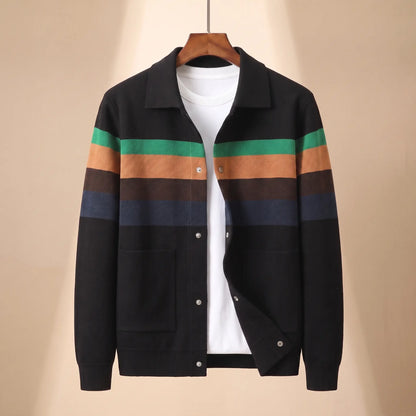Chest Band Knit in black with green chest bands, a colour blocked knit jacket with a turn down collar and snap placket on a wooden hanger