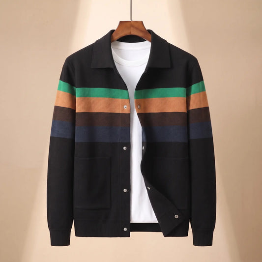 Chest Band Knit in black with green chest bands, a colour blocked knit jacket with a turn down collar and snap placket on a wooden hanger