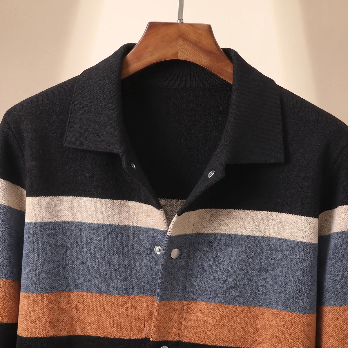 Close up of the flat turn down collar, silver snap buttons and chest bands on the black orange Chest Band Knit