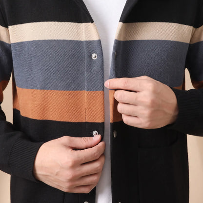 Man closing a snap button on the black orange Chest Band Knit worn over a white tee