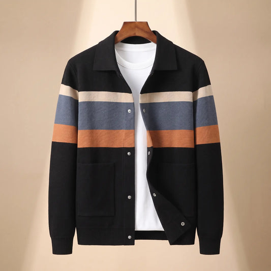 Chest Band Knit in black with orange chest bands, a colour blocked knit jacket with a turn down collar and snap placket on a wooden hanger