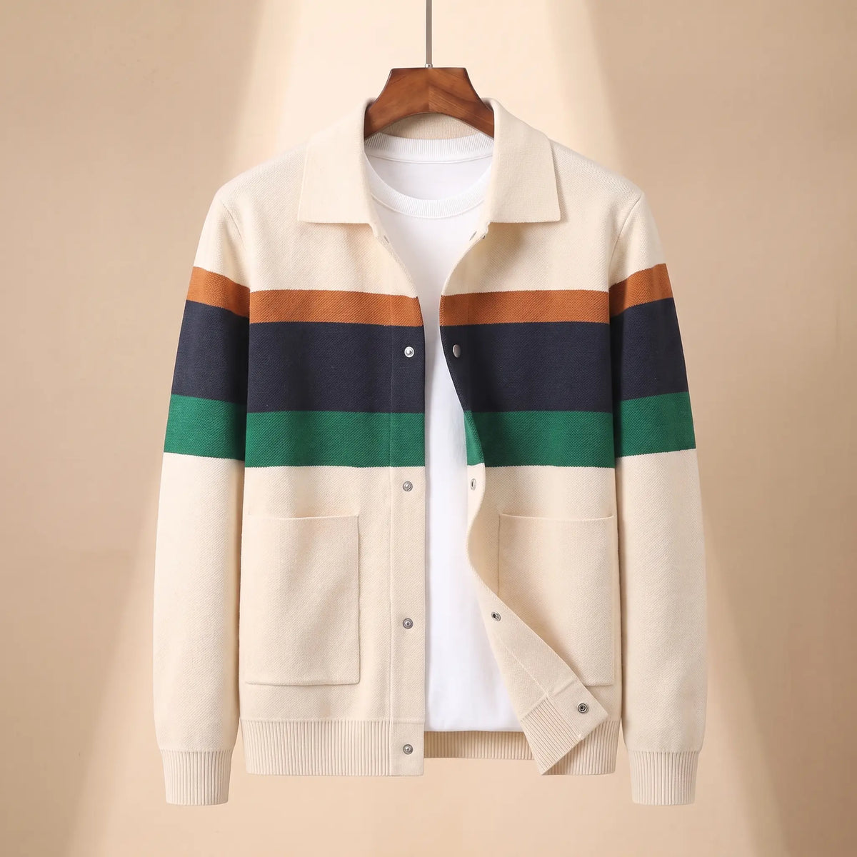 Chest Band Knit in cream with colour chest bands, a colour blocked knit jacket with a turn down collar and snap placket on a wooden hanger
