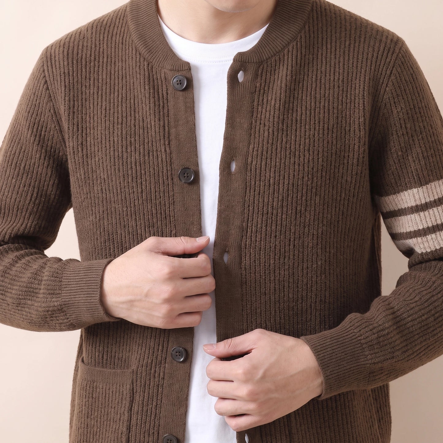 Man wearing knit button cardigan, adjusting hem