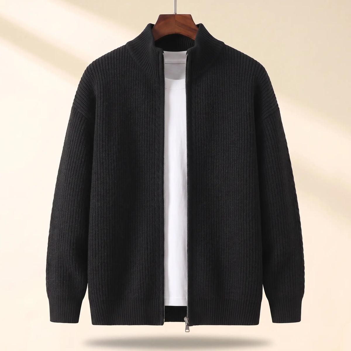 Cold Weather Cardigan in black, a thick ribbed knit full zip cardigan jacket with a stand collar on a wooden hanger