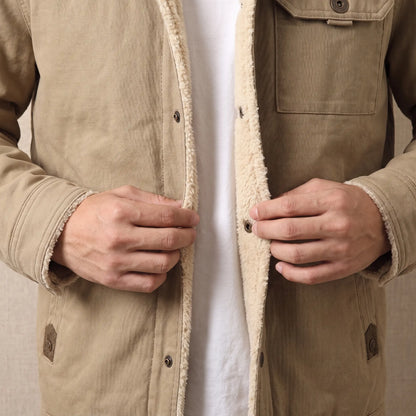 Man fastening the snap front of the canvas jacket